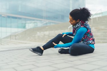 Sportswoman with broken leg sitting on ground,Barcelona