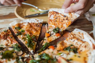 A young woman is eating a freshly made pesto mushroom pizzadilla