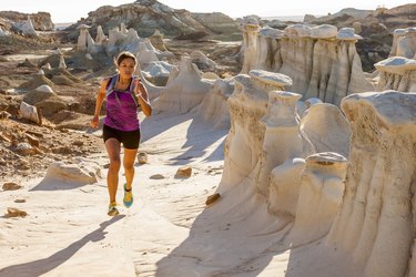 Person running in the desert wearing a running backpack