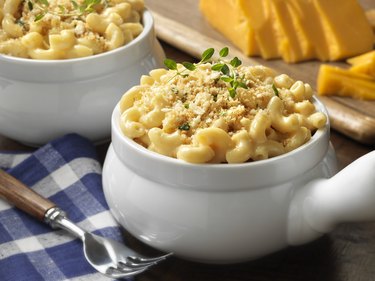 Macaroni and cheese in a white bowl on blue plaid tablecloth