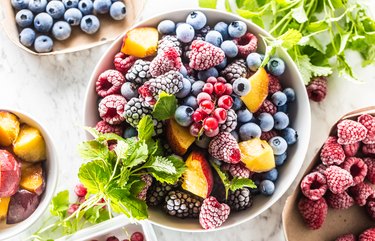 Frozen fruits blueberries blackberry raspberry red currant peach and herbs