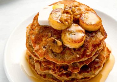 Walnut banana protein pancakes topped with fresh banana slices and walnuts