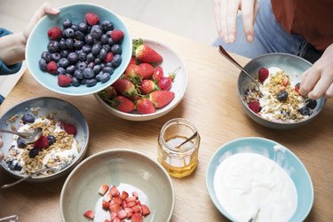 Top view of women sharing breakfast at kitchen table with blueberries for brain health