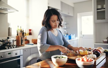 Person preparing their favorite meal in the kitchen, using an intuitive eating style