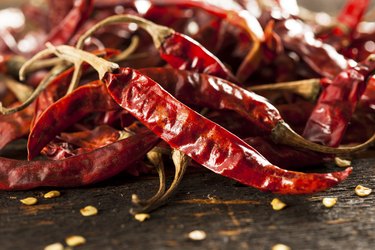 Dried red cayenne peppers on a table to show how many teaspoons of cayenne pepper you should have in a day