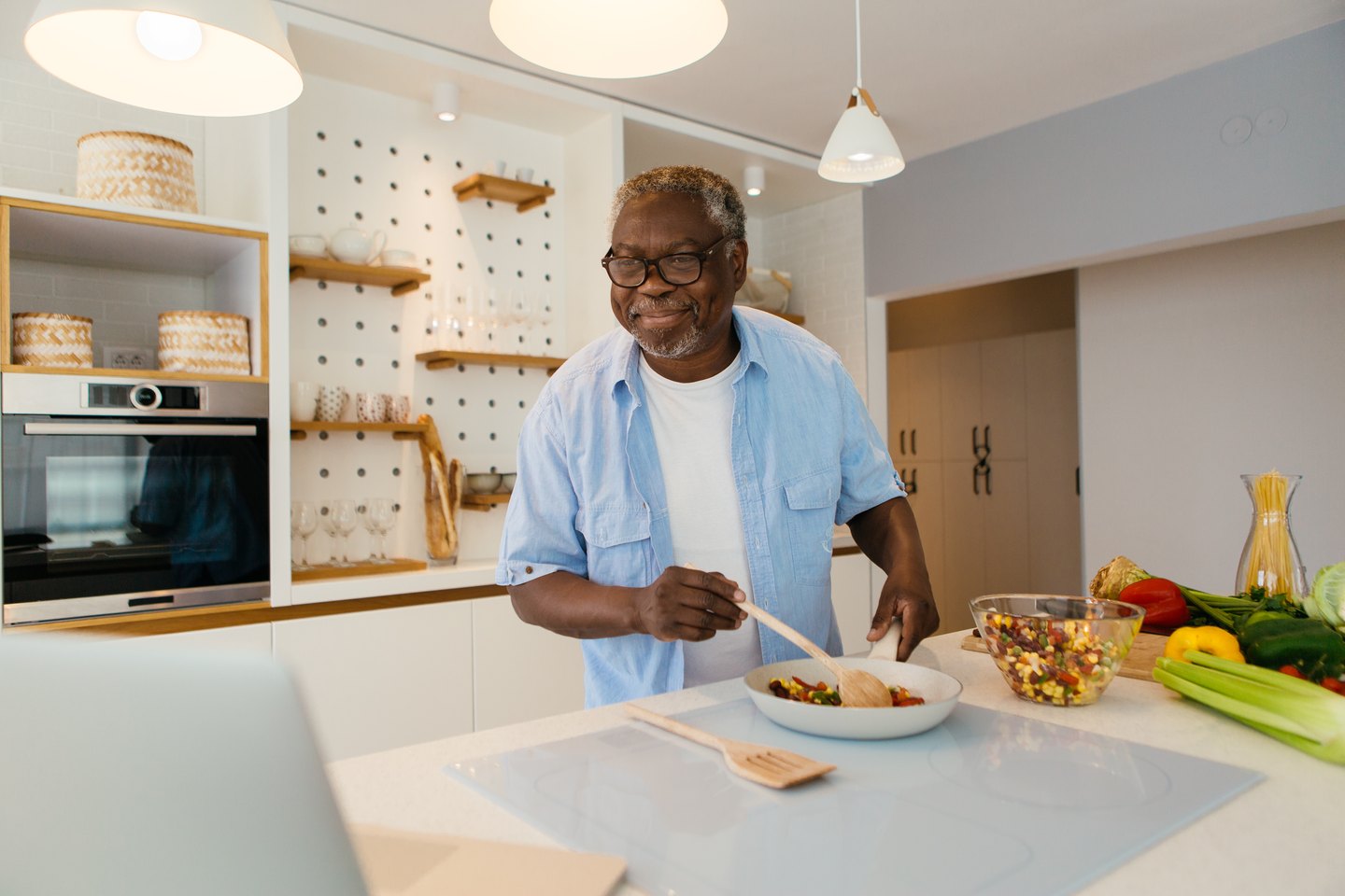 A smiling gentleman cooking in his kitchen