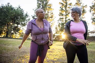 Two people wearing activewear and walking through a field, as an example of remedies for frequent urination at night