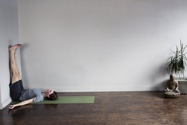 Person in living room doing legs up the wall pose.