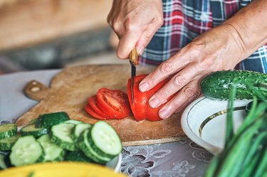 close up of hands cutting vegetables for meal prep