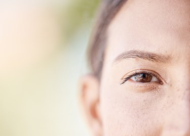 close view of a person's brown eye and eyebrow, to represent eyebrow dandruff