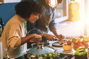 Friends Cooking Together in the kitchen with fresh veggies on counter