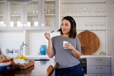 Woman eating  gluten-free  yogurt in the kitchen