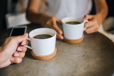 people holding cups of coffee, one of the best drinks for inflammation, sitting at a table