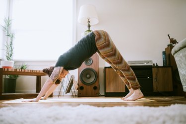 Young Adult Woman At Home Practicing Yoga