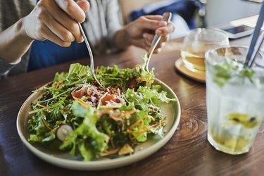 close view of a person eating salad, as an example of foods to eat on the daniel fast