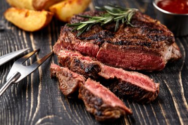 Cross rib steak cooked on the grill on wooden table.