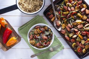 Sheet Pan Sausage dinner on table with plates