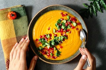 Orange soup topped with pomegranate seeds