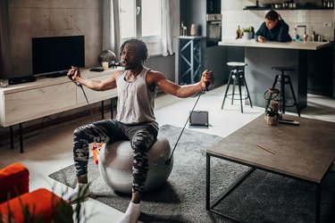 fit person doing a seated shoulder workout in living room