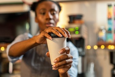 Woman putting the lid on a coffee