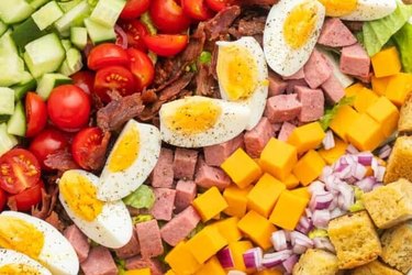 a close up of Chef Salad with ham, hard-boiled egg, cucumber and croutons