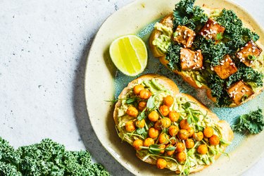 Vegan open sandwiches for bone health with guacamole, tofu, chickpeas and sprouts on a plate.