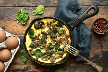 Omelette with mushrooms and spinach in a cast iron pan