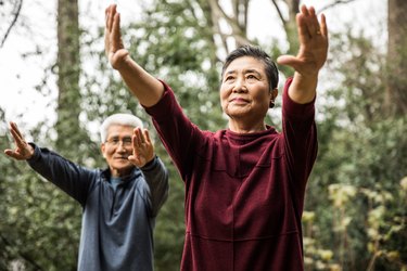 Senior couple doing tai chi outdoors.