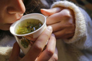 close view of a woman drinking herbal tea instead of coffee, as a natural remedy for high blood pressure