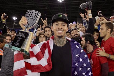 Nyjah Huston with skateboarding award and American flag