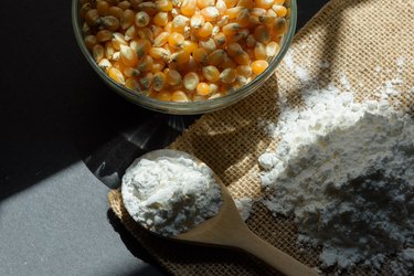 Cornstarch on table in wooden spoon.