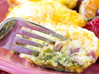 A fork digs into an egg bite made with ham, broccoli and cheese