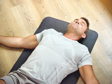 Shot of a mature adult lying on the floor doing constructive rest