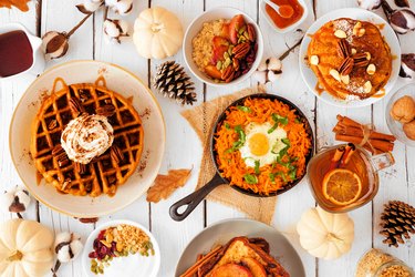 Autumn breakfast or brunch buffet table with sweet potato recipes against a white wood background