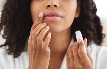 Person applying lip balm to treat their chapped lips