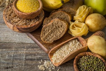 Selection of complex carbohydrates sources including rice and potatoes on wood background