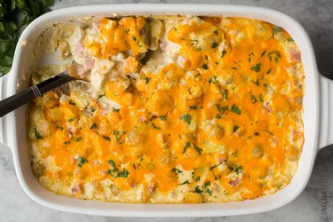 an overhead photo of a white casserole dish with Cheesy Ham and Potato Casserole