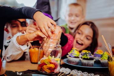 Children grabbing Halloween candy out of jar