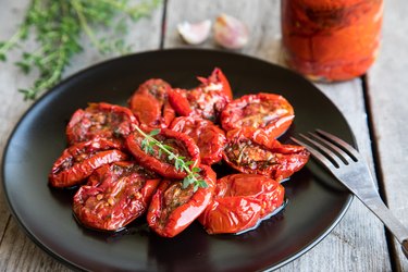 Bowl of sun dried tomatoes on wooden background.