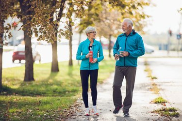 Mature couple walking together with water bottles